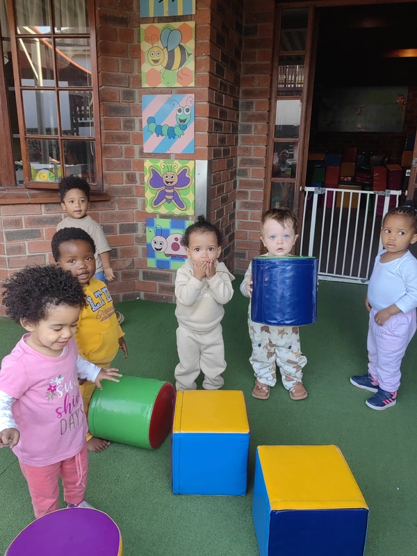 Children playing with colorful foam blocks in a room with insect-themed wall art. Children playing with colorful foam blocks in a room with insect-themed wall art.