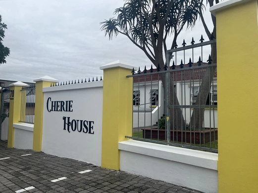The entrance to Cherie House, featuring a welcoming doorway and elegant architectural details, surrounded by lush greenery.