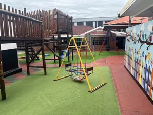 A colorful playground scene showcasing a swing set, complete with a swing, perfect for children