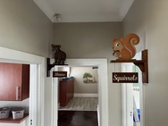 A hallway featuring a wall sign that reads "squirrel," indicating a playful or whimsical theme in the environment.