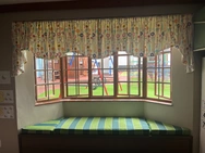 A charming window seat featuring a green and white striped cushion, perfect for enjoying a view or reading a book.