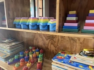A wooden shelf filled with colorful toys and books, creating a cozy and playful atmosphere in a room.
