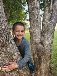 A young boy grinning widely, his smile radiating happiness and positivity in a fun and lively setting.